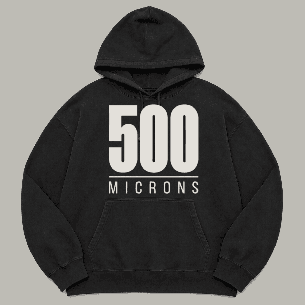 500 MICRONS printed on a black garment-dyed hoodie